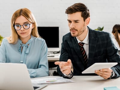 A woman and man looking at a laptop during work | Digital marketing vs. traditional marketing