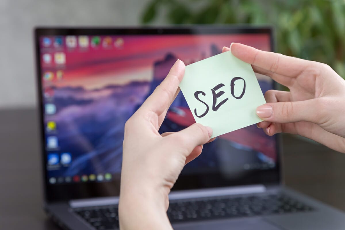 Note with SEO written on it in front of Laptop Screen