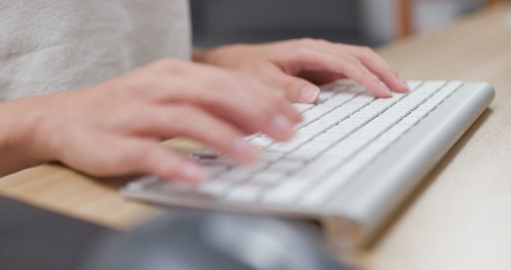 Hands typing on keyboard | SEO Keywords blog post