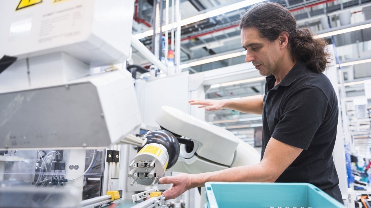 Worker operates a machine during manufacturing process
